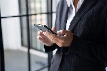 Asian Business woman using smart phone spending time checking news social media