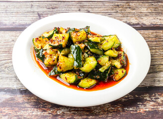 Spicy cucumber in sauce served in plate isolated on wooden table side view of hong kong food
