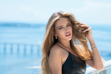 Naklejka premium Beautiful tender woman posing outside. Cosmetics. Sensual woman with bare shoulders posing sensually. Young sensual woman with nude make-up outdoor. Perfect skin, beauty face.