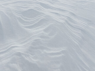 Snow Dune. Abstract natural background of snow dunes and snow drifts. Strong wind makes bizarre snow patterns and textures on the surface of the field