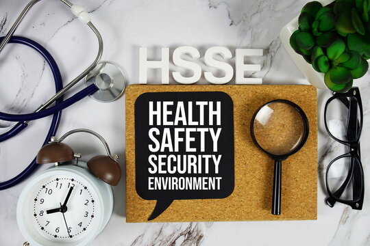 HSSE - Health, Safety, Security & Environment acronym with stethoscope, alarm clock and magnifying glass, medical and healthcare concept background