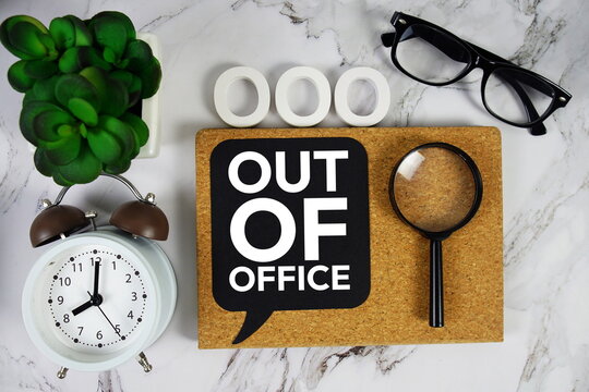 OOO - Out of Office acronym with alarm clock and magnifying glass, business concept background