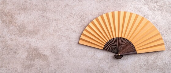 A wooden hand fan in a semi-open position rests on a textured background, showcasing its elegant design and craftsmanship.