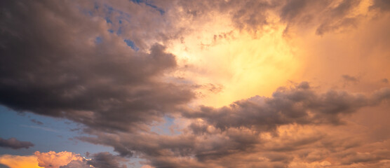 Obraz premium Sunset background. Dramatic majestic scenery sunset. Sky with clouds in sunset sky light background. Sunrise with clouds in various shapes. Calm sunset sky and sun through clouds over.