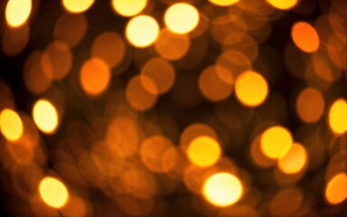 A blurred background of warm, glowing orange lights creating a festive atmosphere.