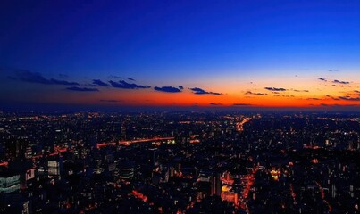 Obraz premium A vibrant city skyline at dusk, showcasing lights and a colorful sunset.