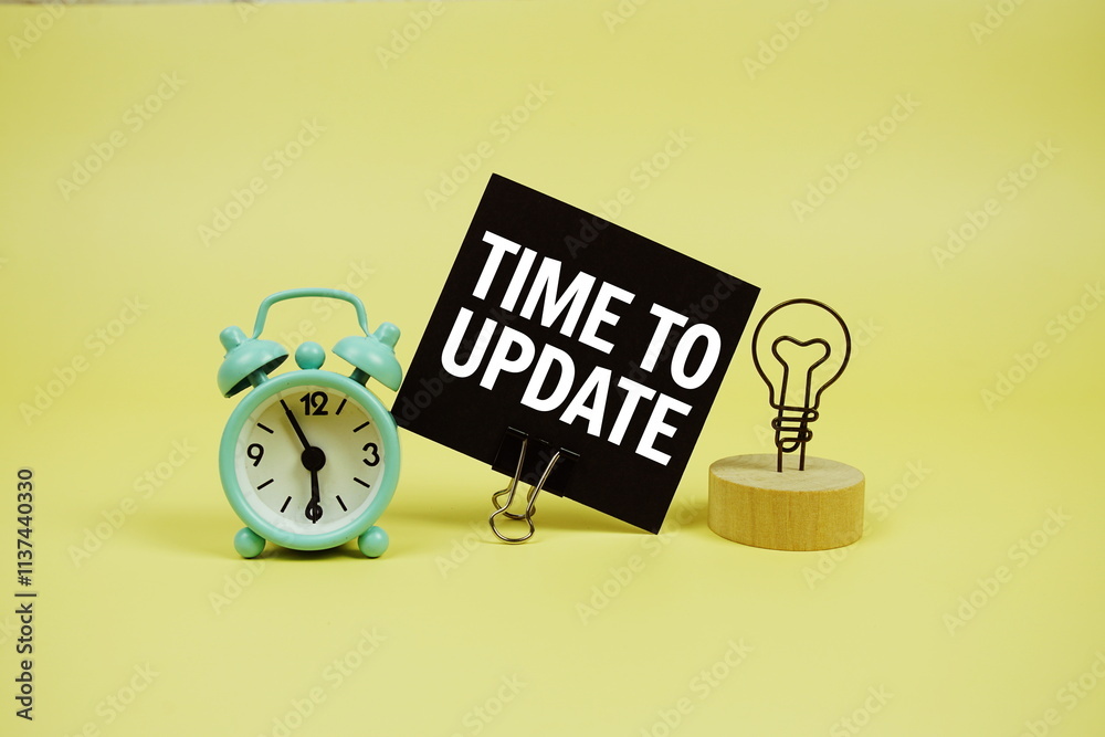 Fototapete time for update text message on paper card with alarm clcok on yellow background