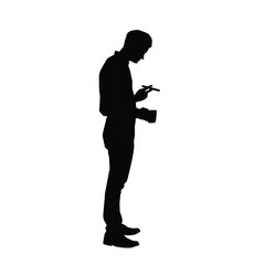 Silhouette of a man standing while smoking and drinking coffee