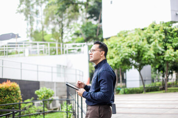 Male Wearing Semi Formal Suit Drawing Using Digital Tablet While Standing on Park