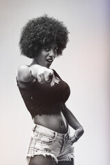Young woman pointing finger and looking at camera