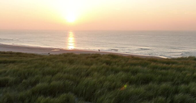 Couple walking on the beach at sunset, relationships, couples, love. Aerial view.