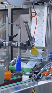 Modern automatic line for labeling dairy products in cans at a dairy factory. The machine automatically marks filled milk cans. Modern dairy mass production. Food industry, dairy plant, conveyor belt