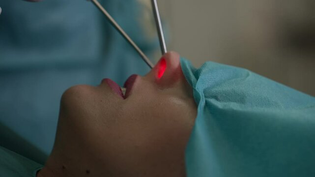 Close-up of a nasal surgery procedure showing a glowing light inside the nostril as medical tools are used. Concept of otolaryngology, surgical precision, and healthcare expertise