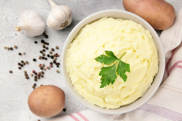 Mashed potatoes in white bowl on grey concrete background. Healthy food
