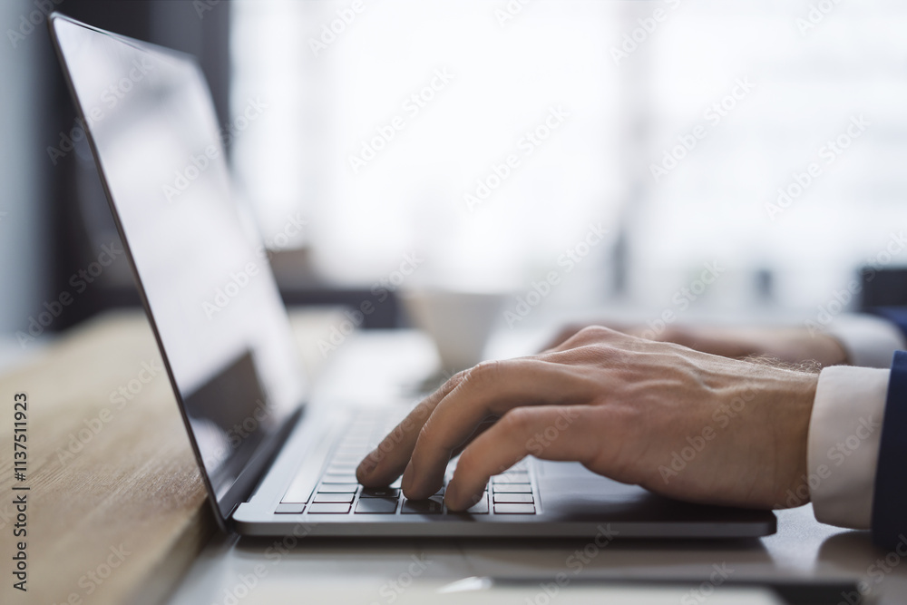 Aufkleber the picture captures a man's hands up close as they type on a sleek laptop keyboard, with an office 