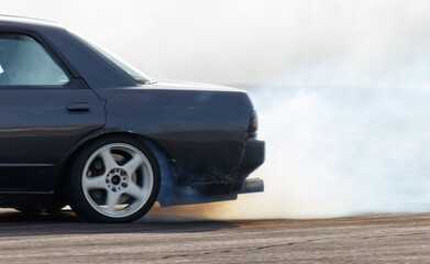 A black car with smoke coming out of the back © schankz