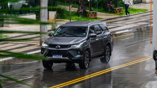Grey Toyota SW4 Fortuner in city traffic, Luxury SUV in the rain, Blurred background