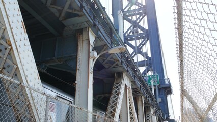 New York City Manhattan Bridge to Brooklyn Dumbo. American subway metro train from pedestrian path. United States public railway transport. Railroad traffic and architecture in USA.