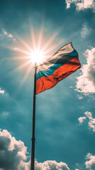 A Russian Federation flag flies high on a flagpole against a blue sky and bright sun.