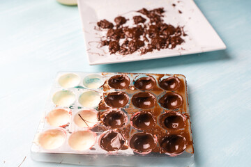 Confectioner's hands fill with chocolate, molds for making homemade chocolates using a cooking bag