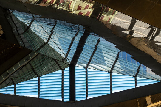 This image showcases striking geometric reflections in architectural glass, connecting the structure to its surroundings and enhancing visual complexity.