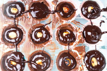 The nut mold is filled with tempered chocolate and ganache. The process of making homemade chocolates.