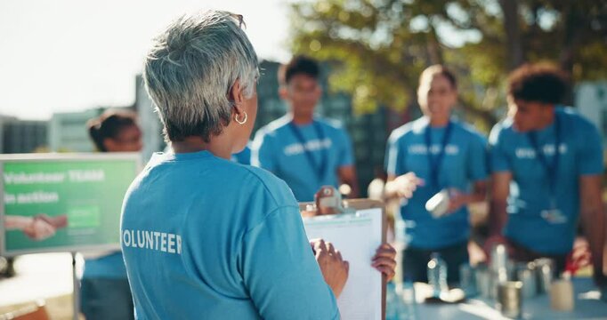 Volunteer, woman and clipboard for food donation, distribution or stock management with team. Charity, community service or mature person help refugee, humanitarian aid or back outdoor with checklist