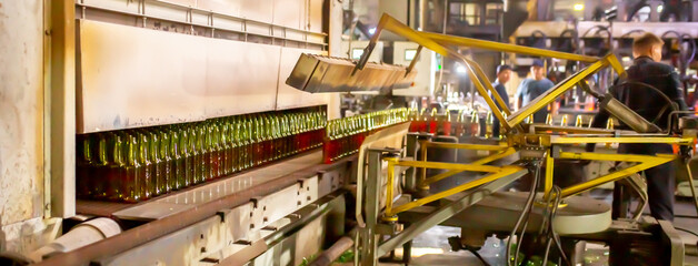 Glass factory, production of glass containers. Molten glass is blown into molds. Robotics in industry. Modern technologies, robotic machines produce products. Technological work at the plant.