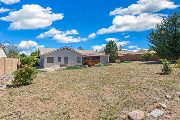 Spacious yard with lush lawn and quaint house view.