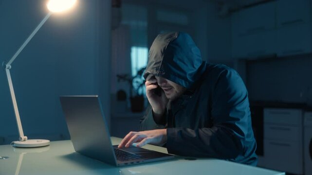 Hacker Typing on Laptop and Talking on Phone in Dark Room, Celebrating Success