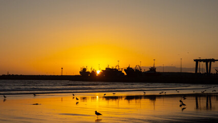sunset on Essaouira beach, in front of the port, in Morocco