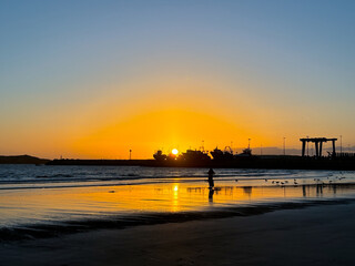 sunset on Essaouira beach, in front of the port, in Morocco