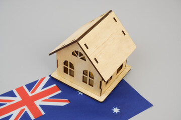 Wooden house on Australian flag on gray background. Real estate in Australia concept.	