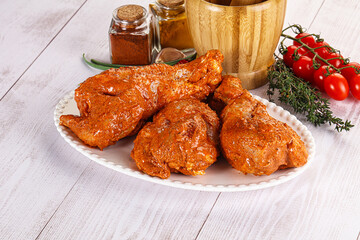 Raw turkey shoulder wing in Indian tandoori marinade