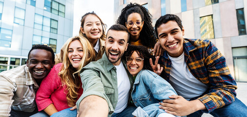 Multicultural group of young people taking selfie pic with smart mobile phone outside - Happy friends looking at camera together - Youth community concept