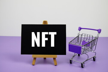 NFT text message and trolley shopping cart on purple background