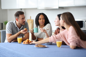 Serious friends at breakfast talking in the kitchen