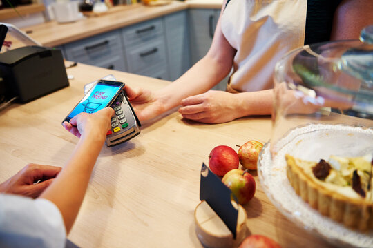 Customer paying cashless with smartphone in a cafe