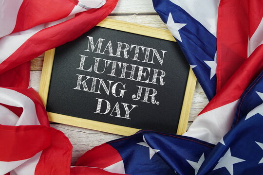 Happy Martin Luther King Jr Day text messege with USA flag on wooden background, America national holiday concept - Powered by Adobe