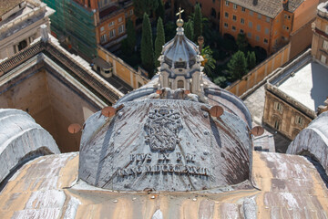 Aerial view from top of Saint Peter's Basilica of dome with metal element with Papal coat of arms, Vatican, Rome, Italy