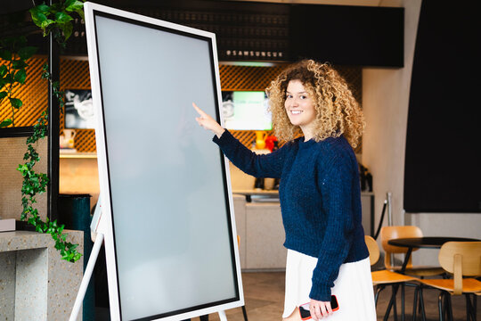 Smiling young woman using interactive whiteboard