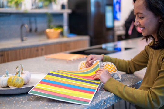 Pregnant woman choosing color from swatch at home