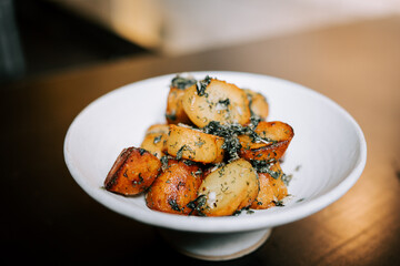 Fried Potatoes With Fresh Herbs Served on a White Plate in a Cozy Dining Atmosphere During Dinner Time