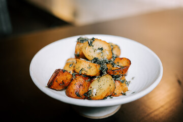 Delicious Fried Potatoes Garnished With Fresh Herbs Served on a White Plate in a Cozy Dining Setting