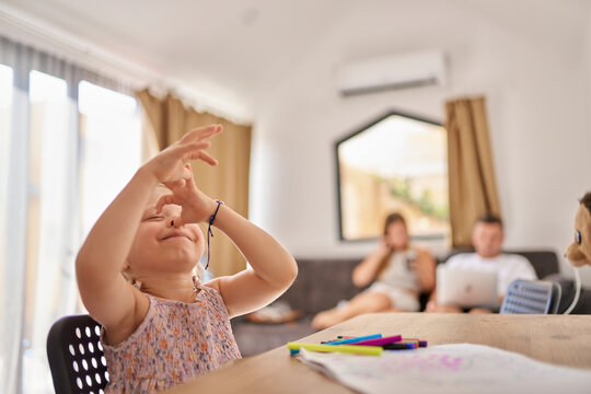 Happy girl gesturing at table in living room