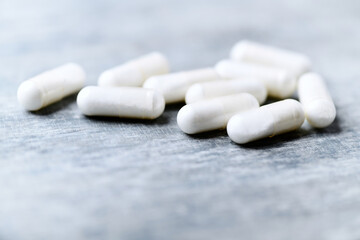 Beta-alanine capsules. Bodybuilding food supplements on wooden background. Soft focus. Close up. Copy space.