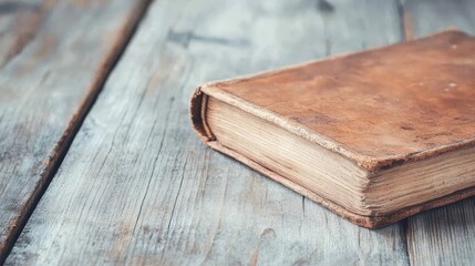 A leather bound book sits on a wooden table