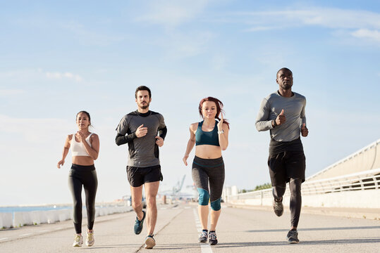 Group of sportspeople jogging at harbour