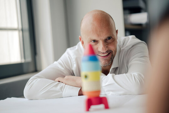 Businessman playing with toy rocket in office