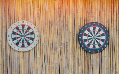 A focused view of a dart piercing a targets setting on bamboo wall